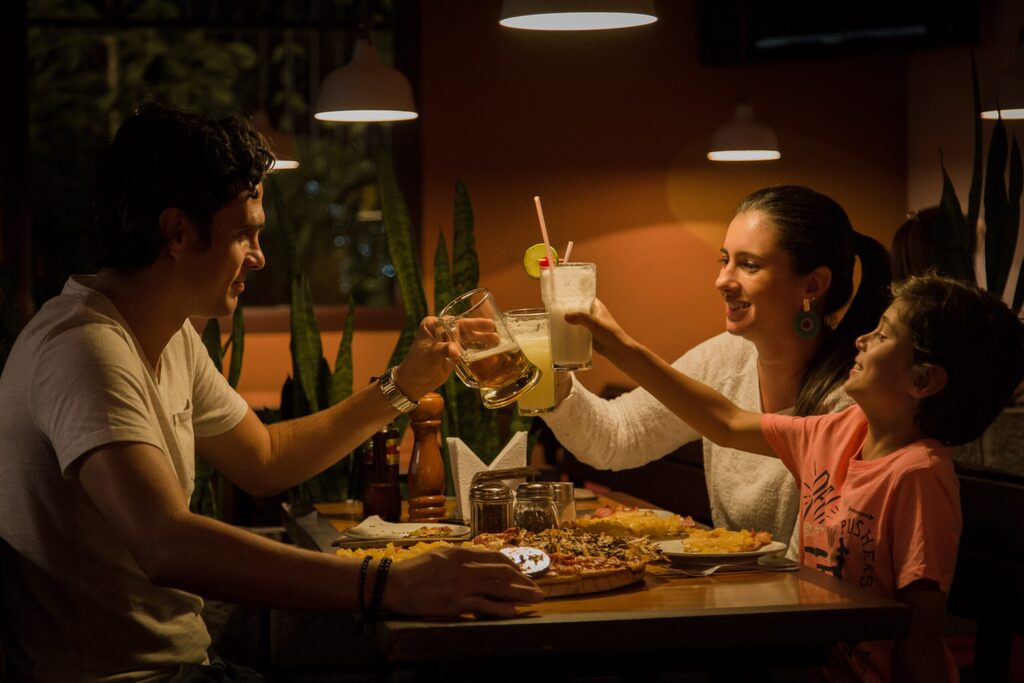 Una familia brinda alrededor de la mesa en un restaurante