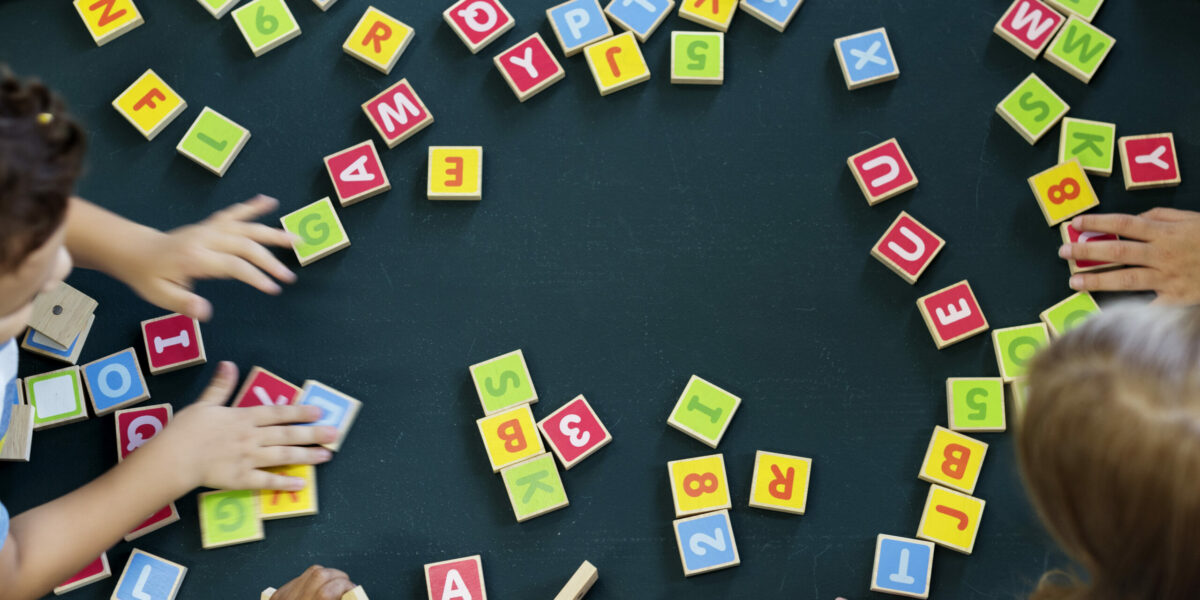 Kindergarten kids playing wooden alphabets letters vocabulary ga Kindergarten kids playing wooden alphabets letters vocabulary game