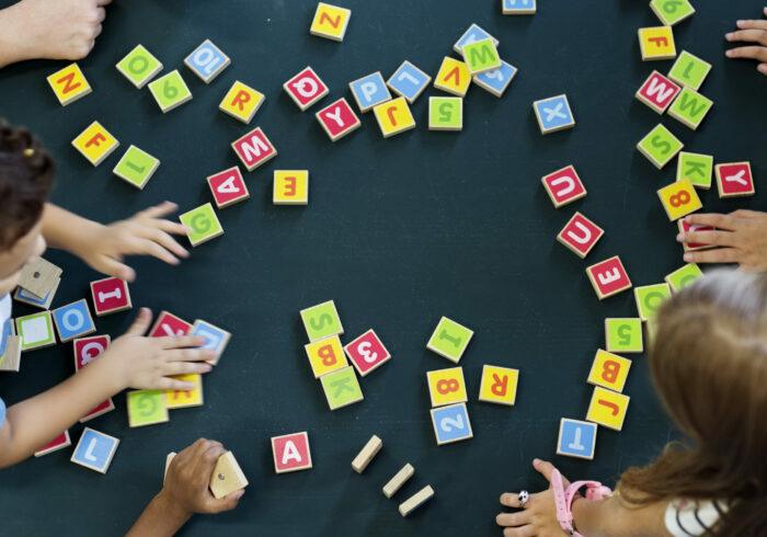 Kindergarten kids playing wooden alphabets letters vocabulary ga Kindergarten kids playing wooden alphabets letters vocabulary game