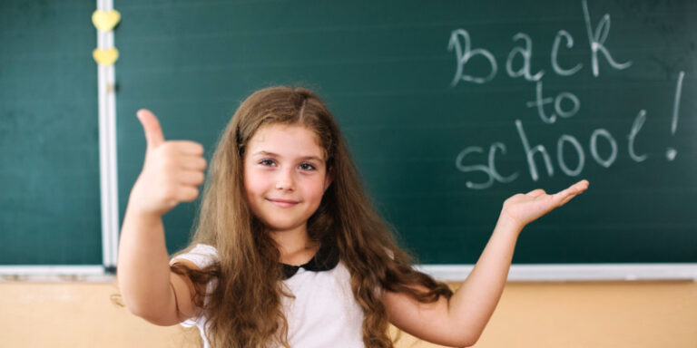 niña celebrando una feliz vuelta al colegio con éxito