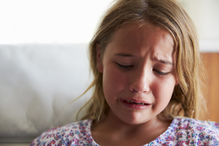 Head And Shoulders Shot Of Upset Girl At Home niña acoso